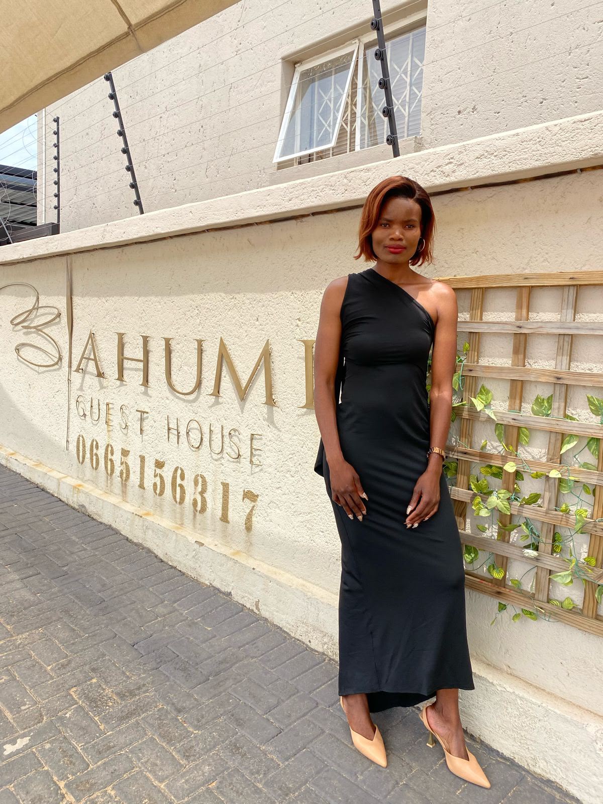 Guest posing at the Bahumi Guest House signage entrance