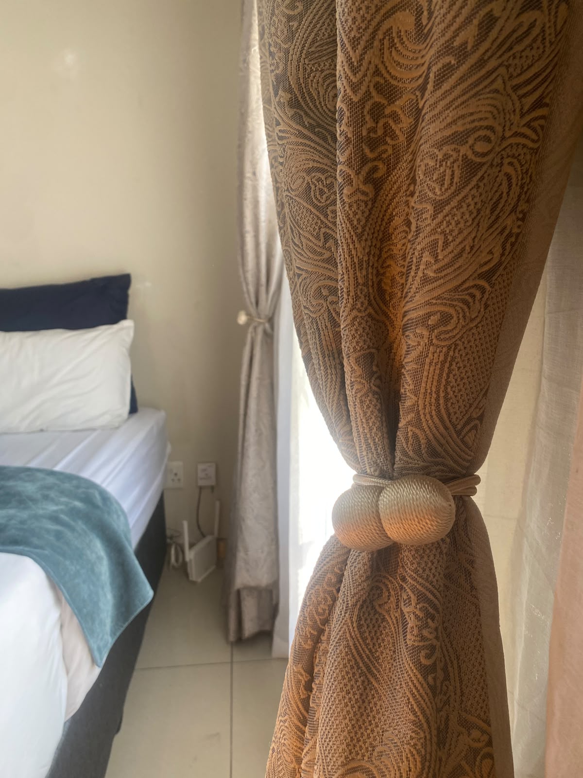 Room 7 bedside view with lace curtains and free Wi-Fi router